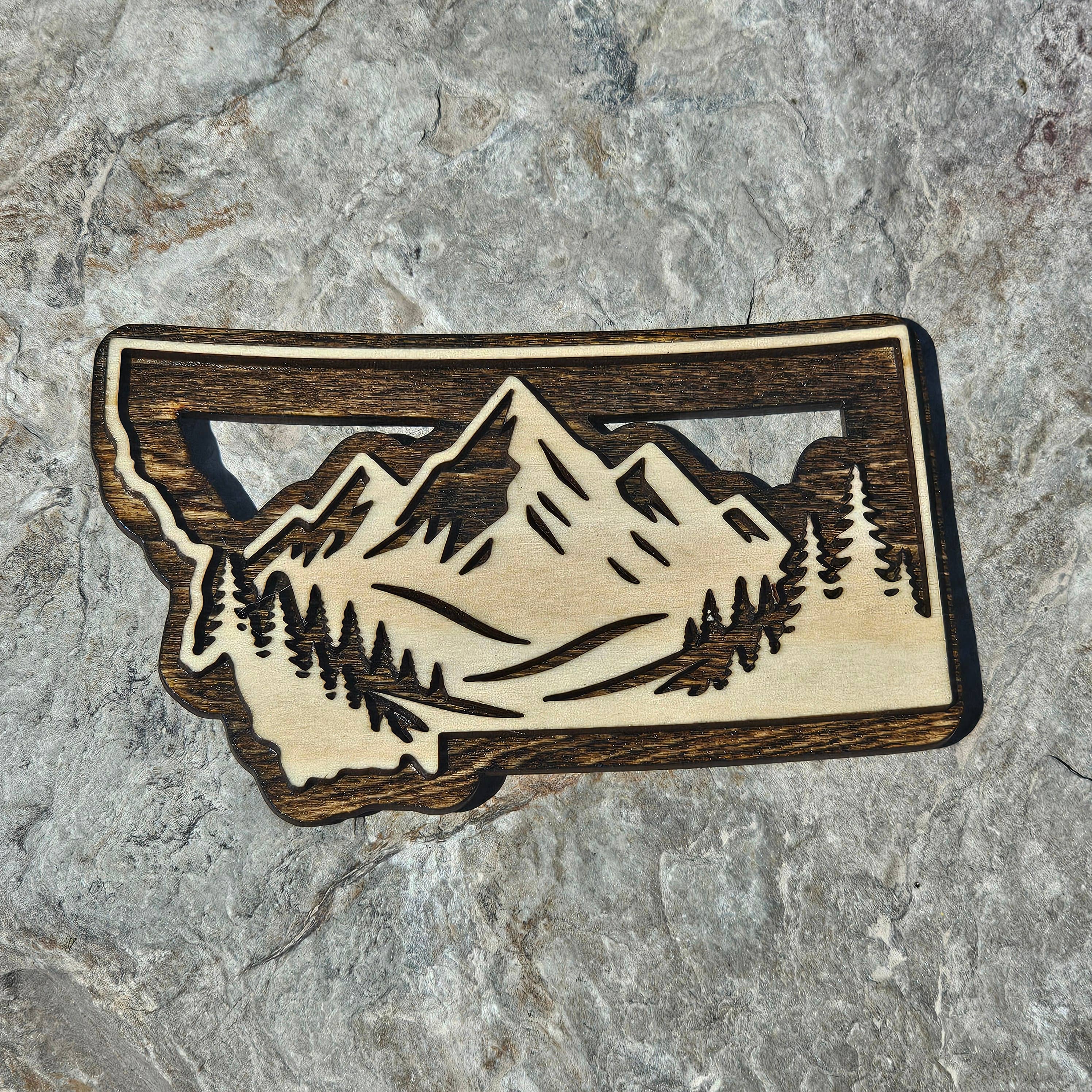 Layered wood Montana state magnet with carved mountain range and pine trees in dark stained and natural wood, from The Ruddy Duck in Whitefish, Montana