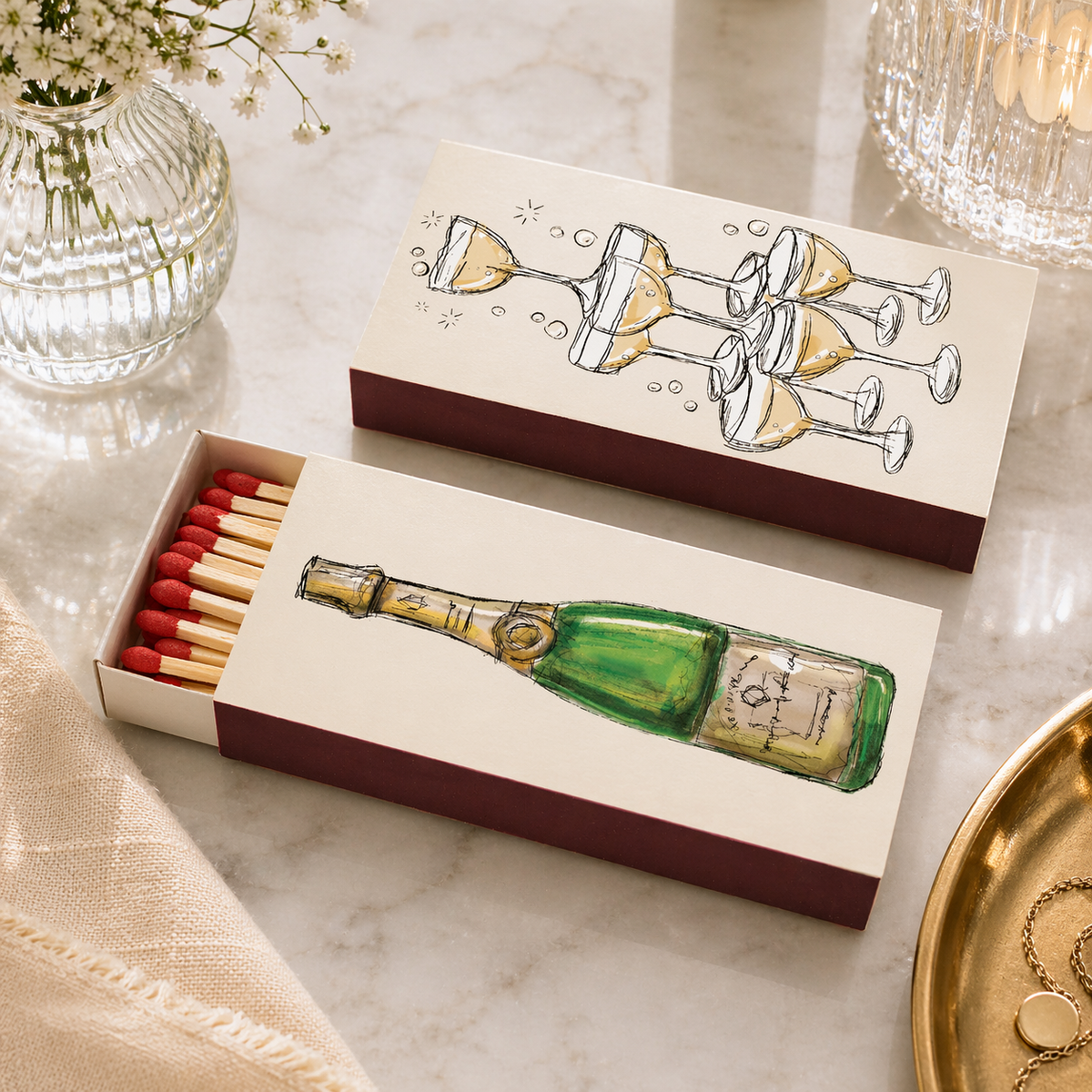 Decorative matchbox with festive champagne design holding 40 long wooden matches, from The Ruddy Duck in Whitefish, Montana