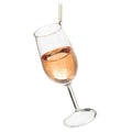 Glass rose wine ornament, a tilted wine glass with a pink pour and gold hanging cord, from The Ruddy Duck in Whitefish, Montana