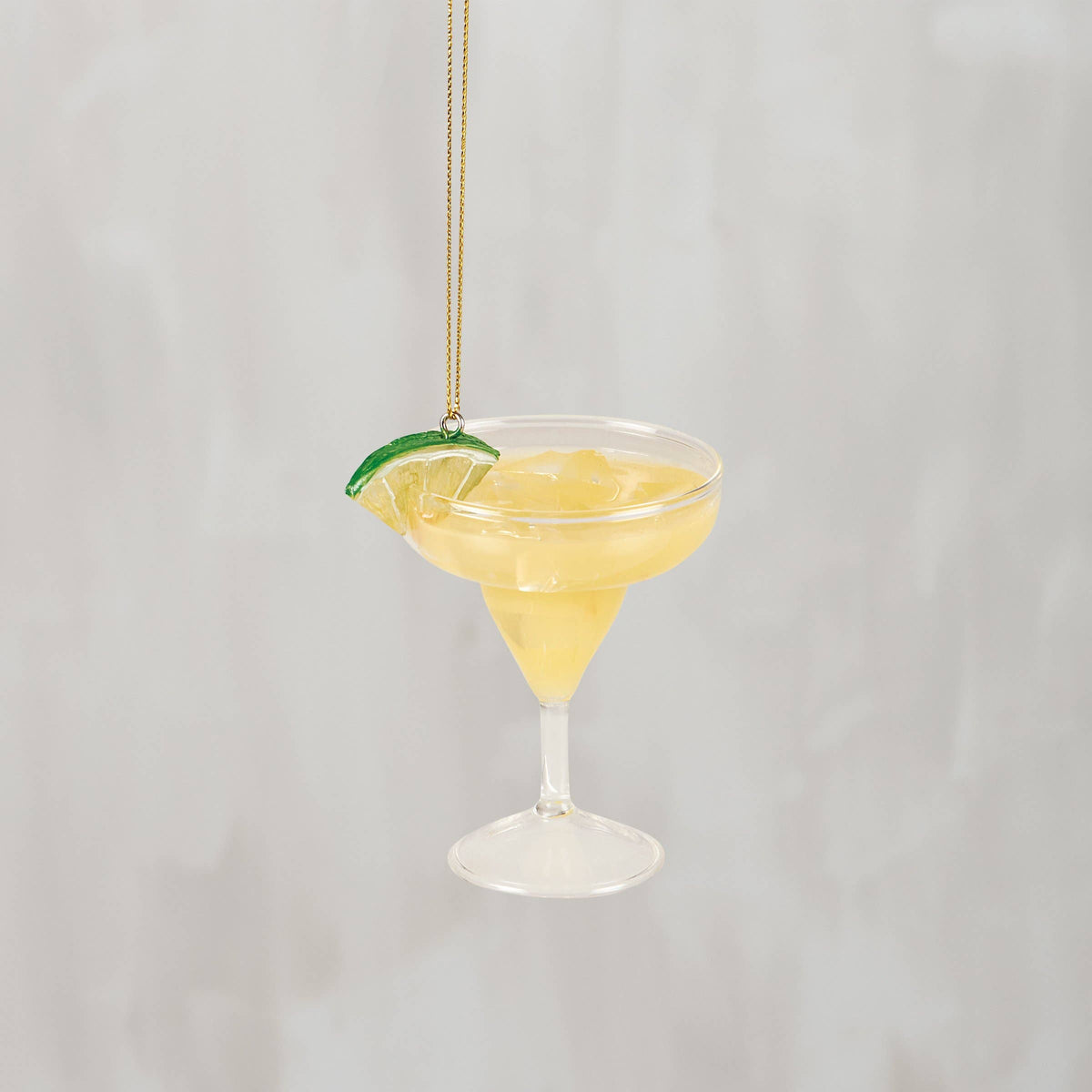 Glass margarita cocktail ornament with a lime wedge on the rim and a gold hanging cord, from The Ruddy Duck in Whitefish, Montana