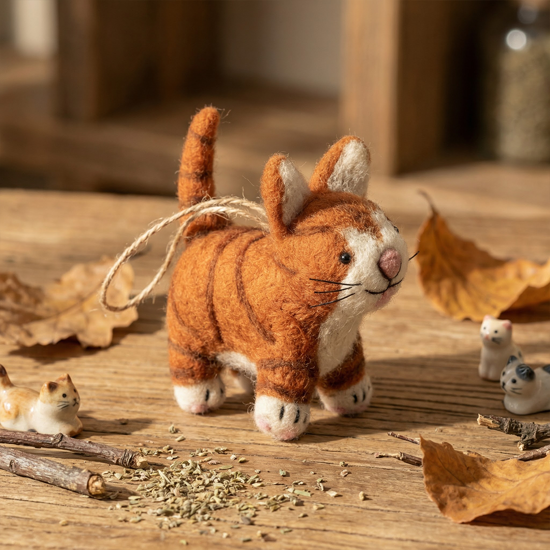 Handmade felt ginger tabby cat decoration with white belly and black stripes, from The Ruddy Duck in Whitefish, Montana