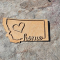 Natural wood Montana state magnet with a raised heart and cursive home script, from The Ruddy Duck in Whitefish, Montana