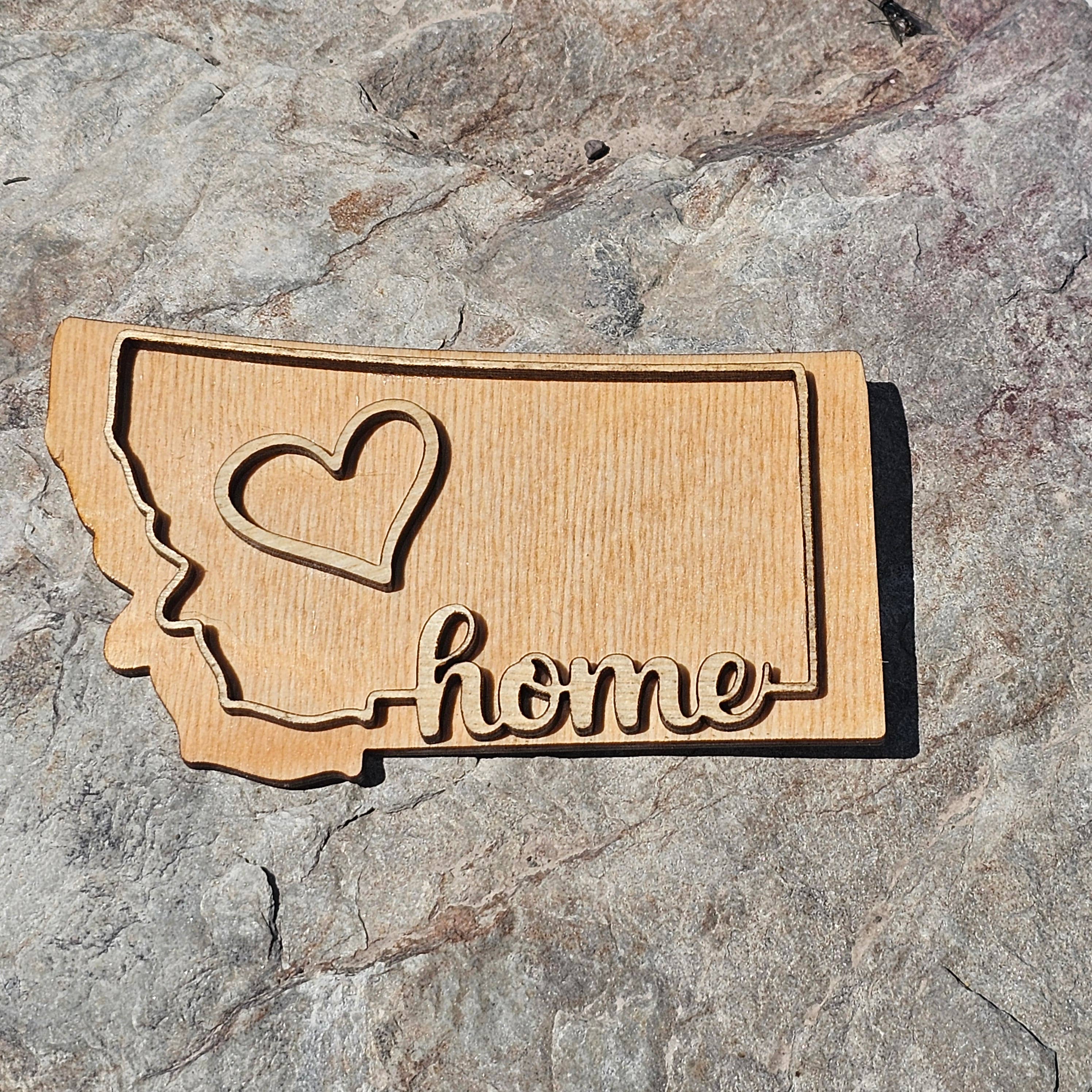 Natural wood Montana state magnet with a raised heart and cursive home script, from The Ruddy Duck in Whitefish, Montana