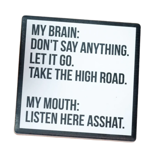 Coaster with humorous text on a wooden surface