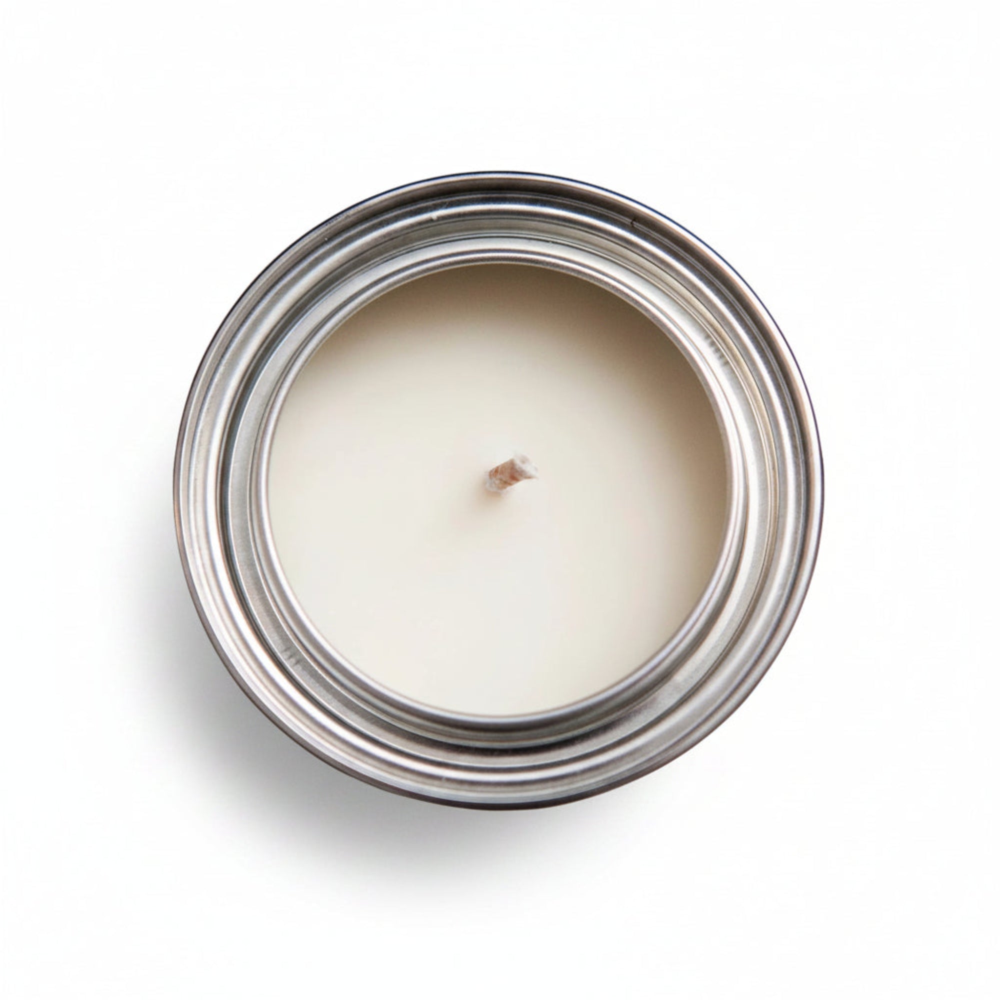 Candle in a metal pint paint can on a white surface