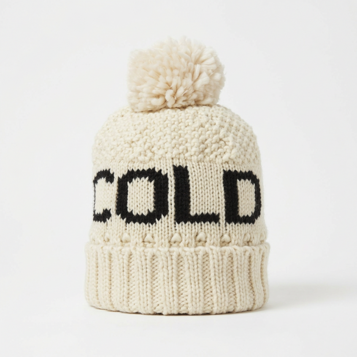 Cream knit pom beanie with a black Cold Alpine design, from The Ruddy Duck in Whitefish, Montana