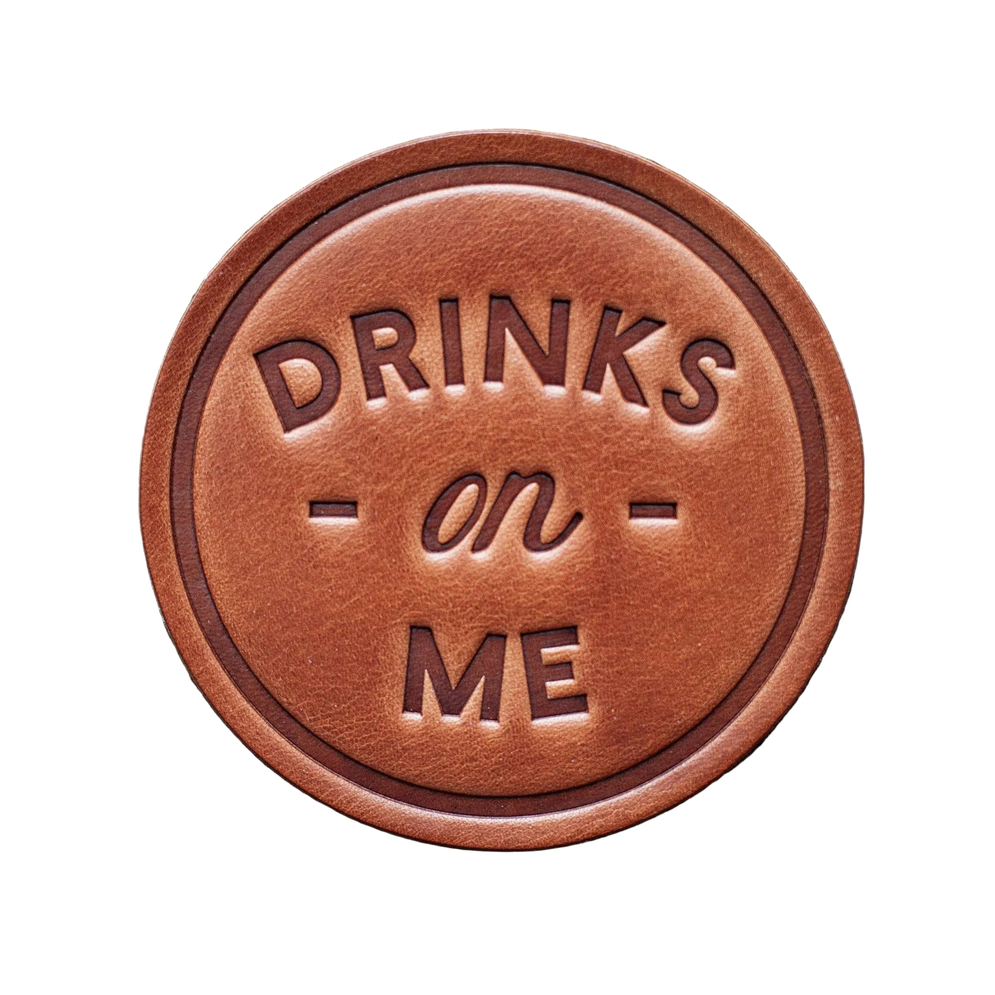 Brown leather sign with 'DRINKS on ME' text on a wooden background