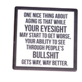 Coaster with humorous quote on a wooden surface