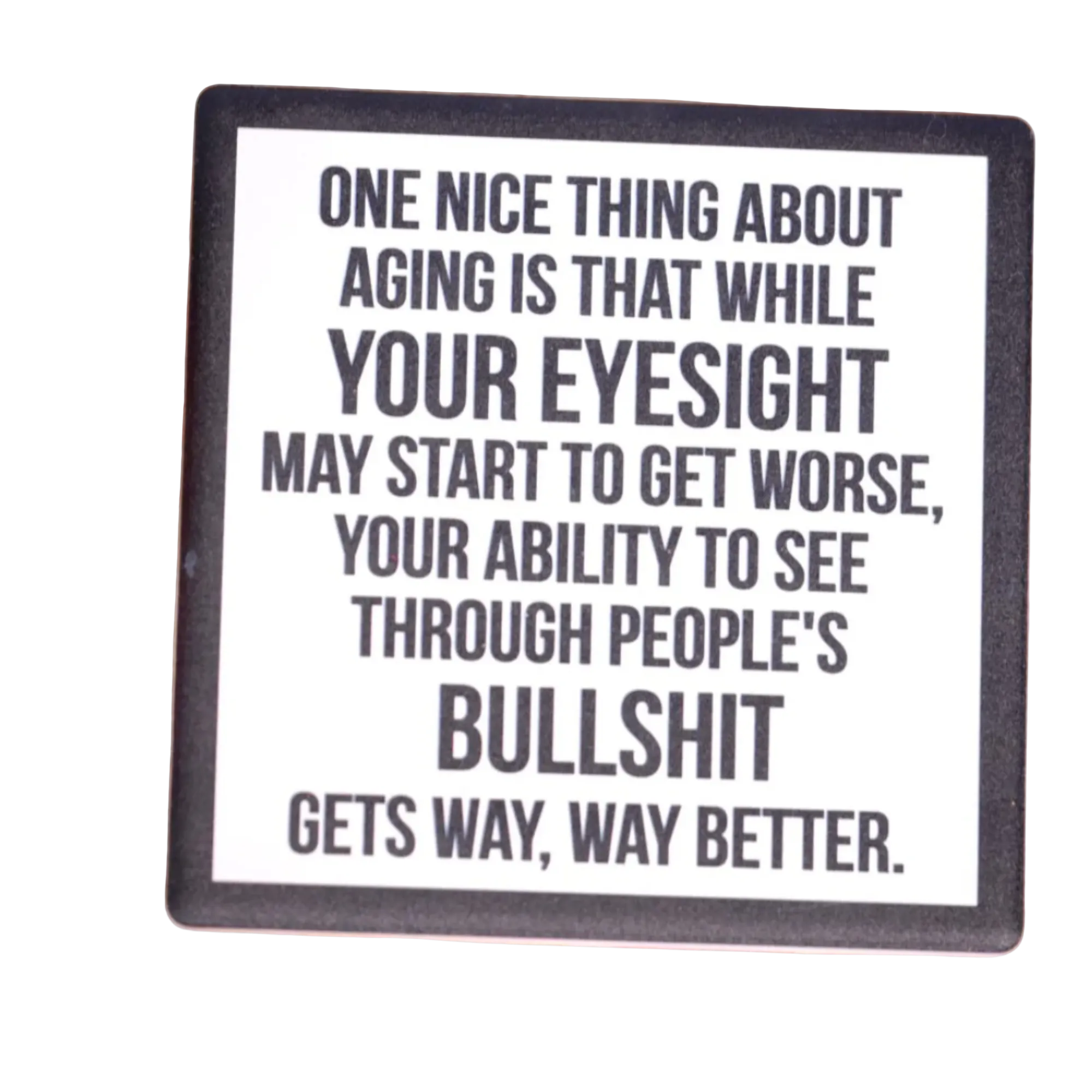 Coaster with humorous quote on a wooden surface