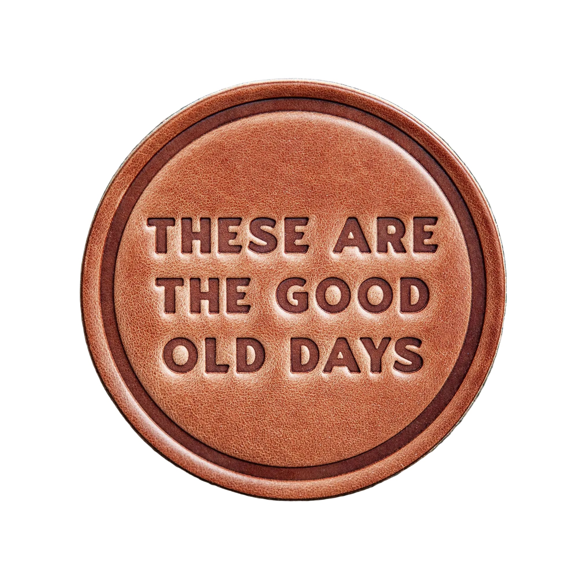 Brown leather patch with 'These are the good old days' text on a wooden background