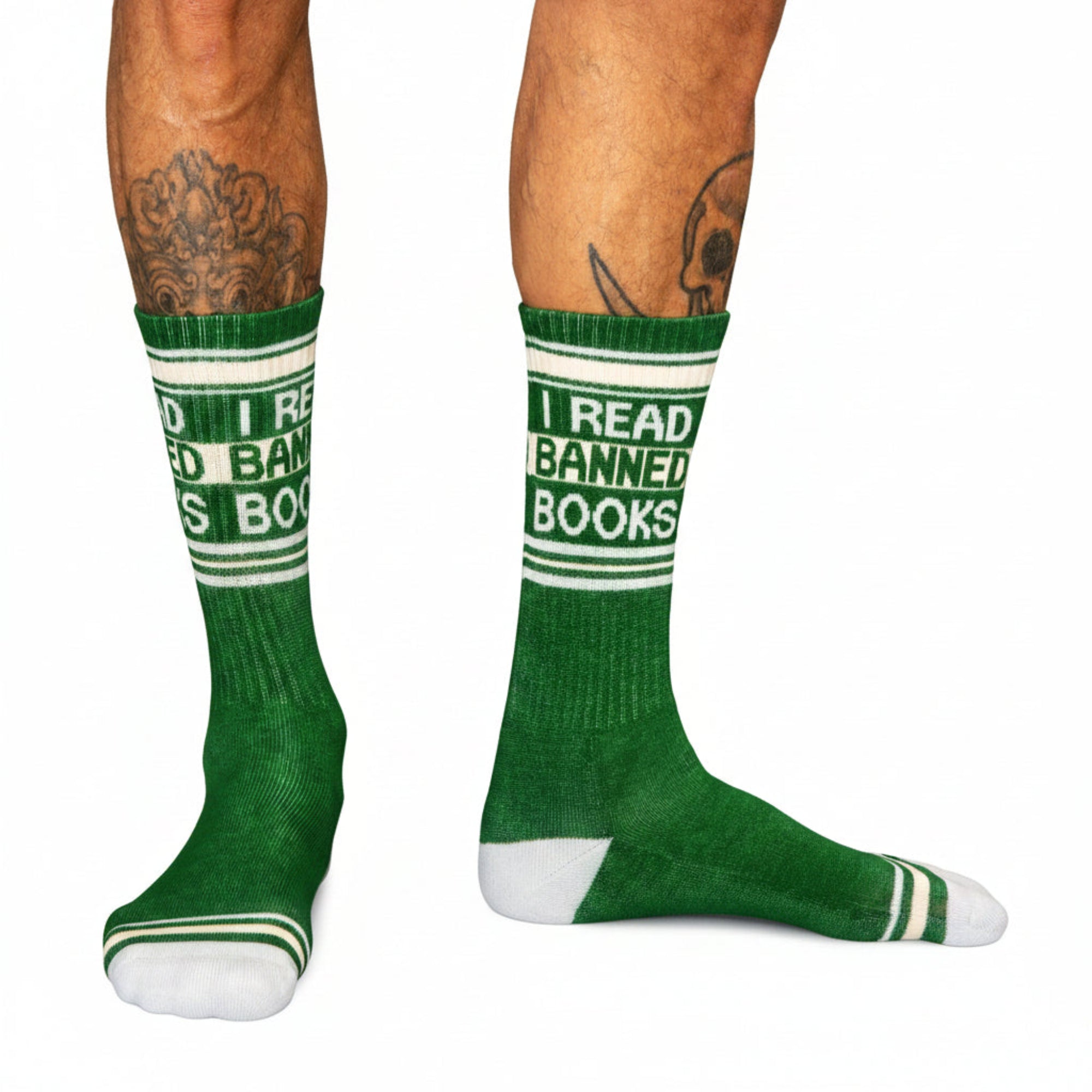 Green socks with 'I Read Banned Books' text worn by a person on a black background