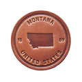 Brown leather patch with 'Montana United States' text on a wooden background