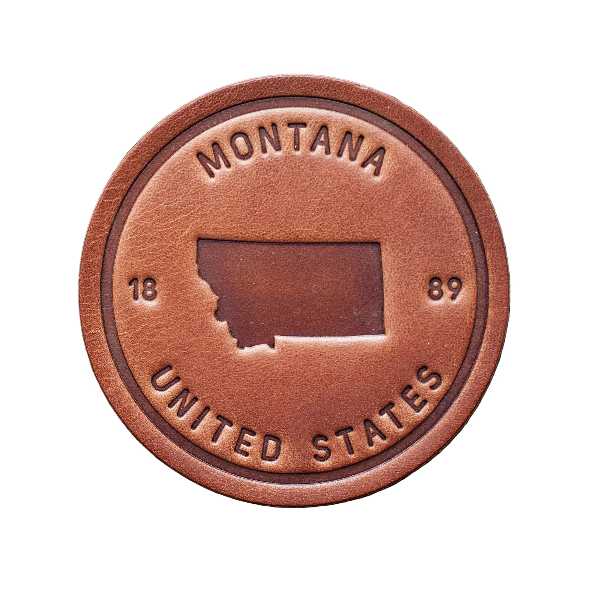 Brown leather patch with 'Montana United States' text on a wooden background