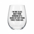 Clear wine glass with humorous text on a white background