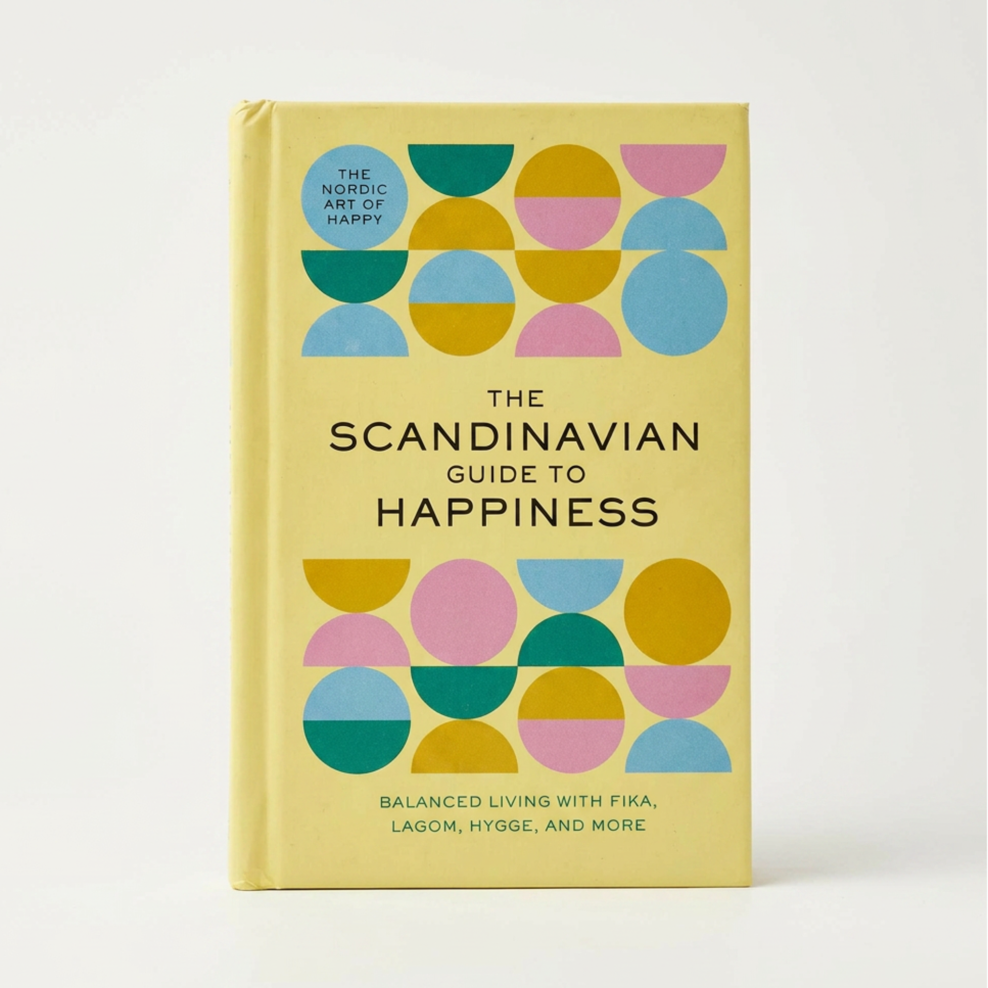 Book titled 'The Scandinavian Guide to Happiness' with colorful geometric design on a light background