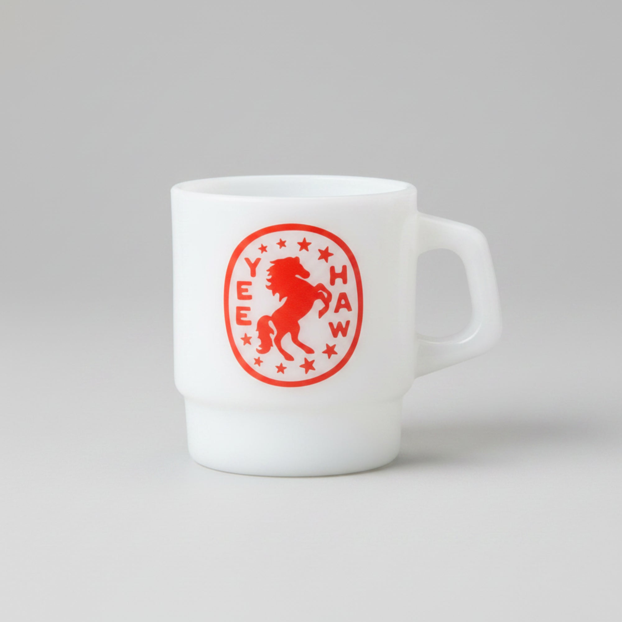 Yee Haw white milk glass mug with red bucking horse and stars badge, retro diner style, from The Ruddy Duck in Whitefish, Montana