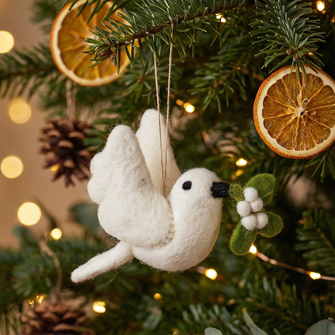 Handmade white felt dove Christmas ornament carrying mistletoe sprig, from The Ruddy Duck in Whitefish, Montana